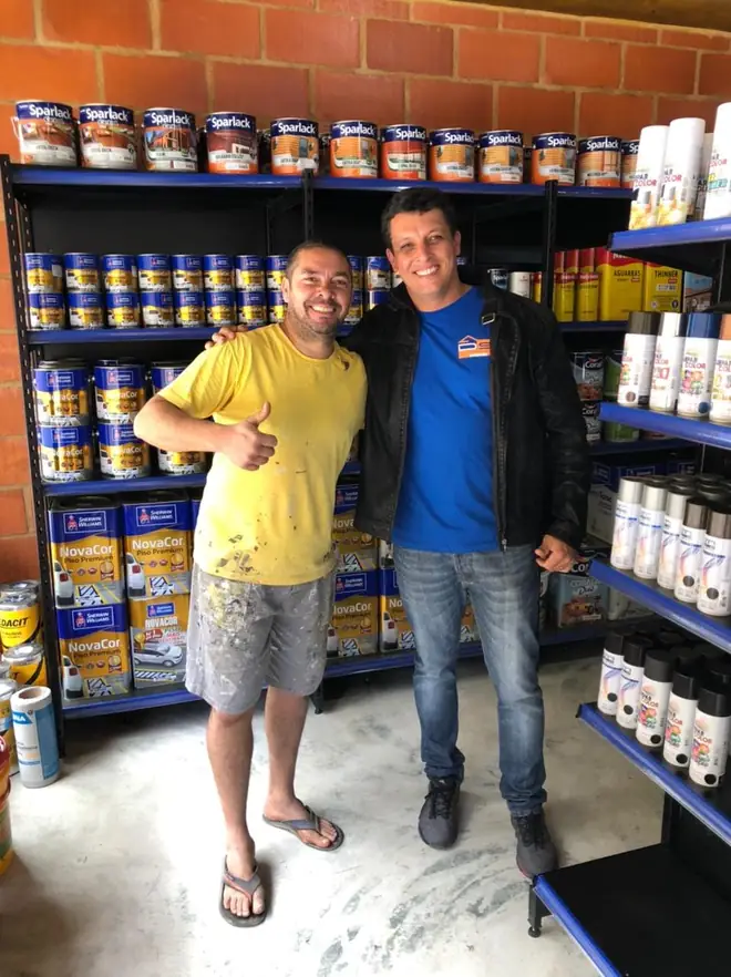 Equipe atendendo cliente na seção de tintas